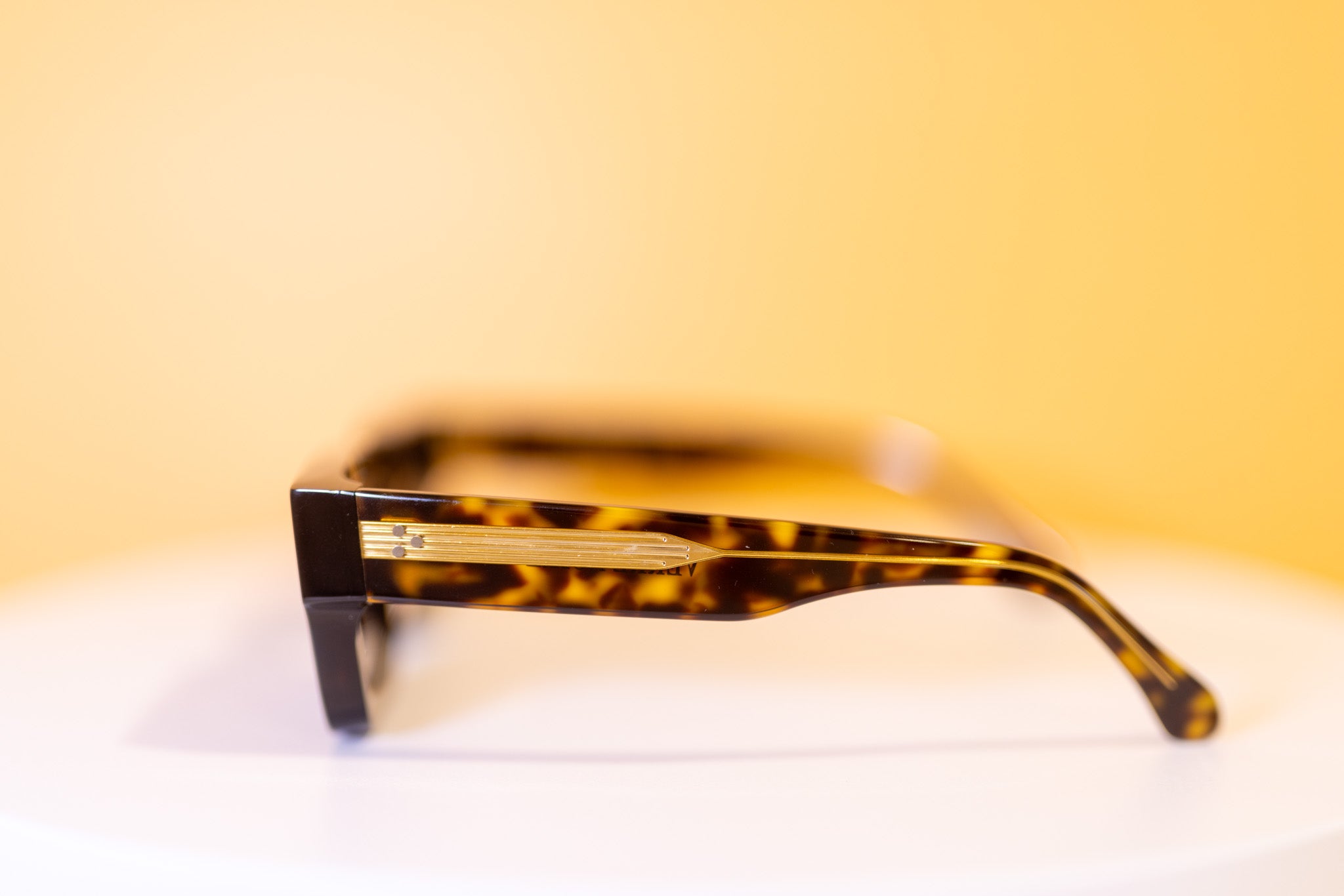 Detail of gold temple on designer sunglasses


