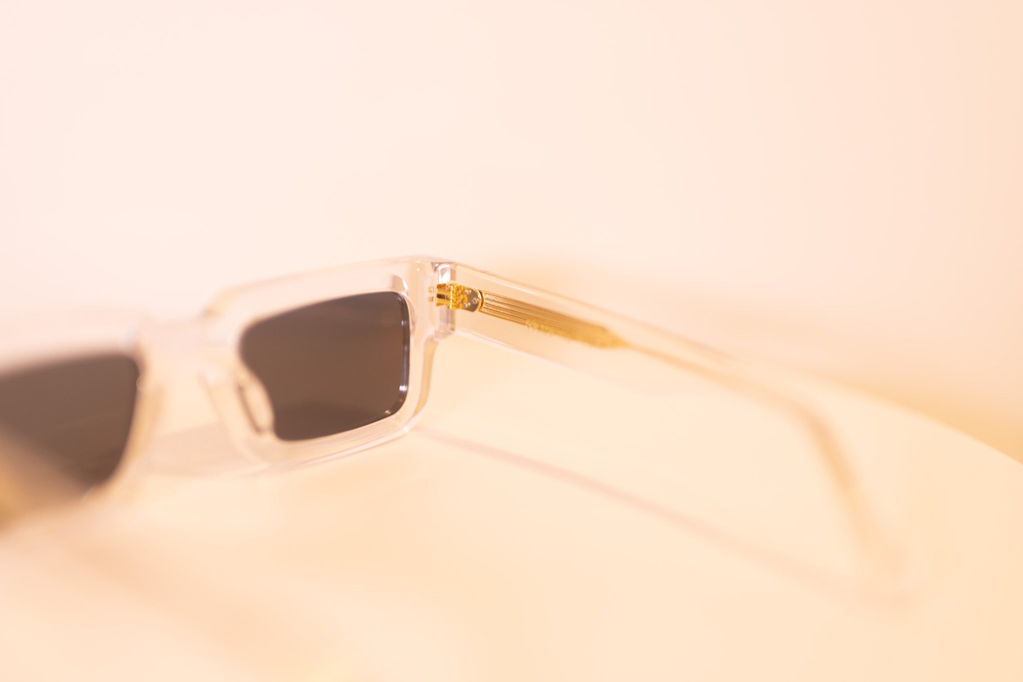 Crystal Elite sunglasses hinge view with transparent frame and gold accents